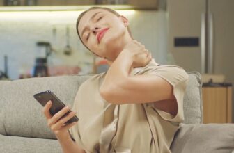 Woman rubbing her neck due to tech neck strain